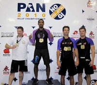 a group of men standing on a podium with medals