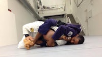 a man in a purple jiu jitsu uniform is doing a jiu jitsu